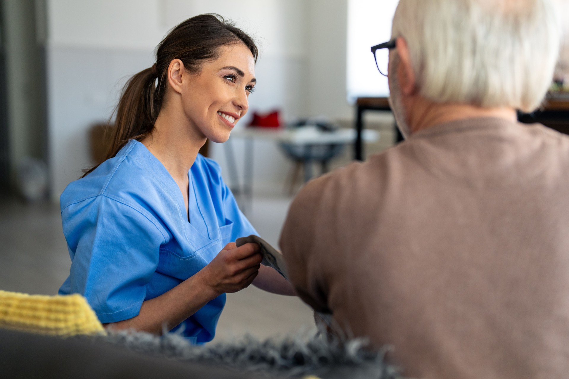Caring Nurse Providing In-Home Health Check to Senior Man